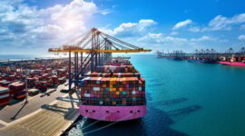 Aerial view of cargo ship and cargo container in harbor.