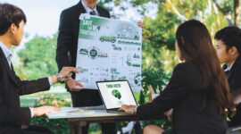 Group of asian business people presenting environmentally friendly development plan and sustainable technology project for greener future, establishing outdoor eco business office at natural park.Gyre