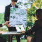 Group of asian business people presenting environmentally friendly development plan and sustainable technology project for greener future, establishing outdoor eco business office at natural park.Gyre