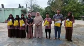 Kepala MAN 3 Padang Hj. Marliza dan Kaur TU Visanola Enggrita, bersama siswa penerima bantuan pada acara penutupan Pesantren Ramadan, Kamis (20/3/2025).