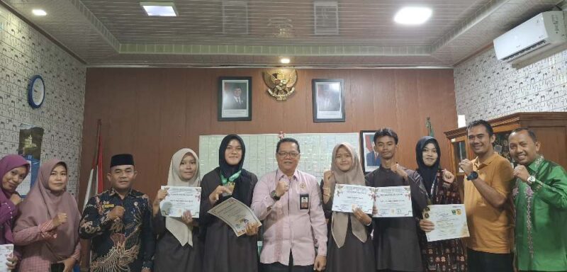 Kakan Kemenag Sawahlunto H. Dedi Wandra dan Kepala MAN Kota Sawahlunto Dafril Tuanku Bandaro bersama siswa penerima apresiasi prestasi nasional dan internasional.