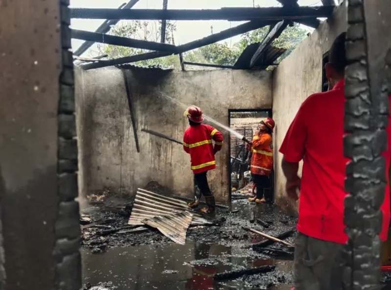 Petugas Damkar Tanah Datar berupaya memadamkan kebakaran rumah permanen di Nagari Tanjung Barulak, Tanjung Emas. (Ist.)