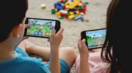 Ilustrasi anak bermain gim daring di ponsel, mencerminkan kontroversi larangan Roblox oleh pemerintah.