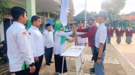 Kepala MAN 3 Kota Padang, Hj. Marliza, saat melakukan prosesi pelantikan Ketua dan Wakil Ketua OSIM terpilih masa bakti 2025-2026 di lapangan madrasah.