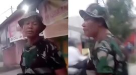 Tangkapan layar video yang viral di media sosial, menunjukkan seorang pria yang mengenakan seragam TNI lengkap sedang berusaha menghindari atau berdebat dengan pengemudi ojol yang menagih ongkos. (Ist.)