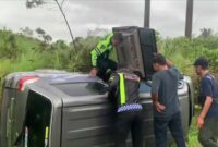 Petugas dari Satlantas Polres Solok saat melakukan penanganan dan evakuasi mobil Suzuki APV yang terguling keluar badan jalan di tikungan S, jalan Lingkar Solok-Padang. (Ist.)
