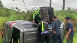 Petugas dari Satlantas Polres Solok saat melakukan penanganan dan evakuasi mobil Suzuki APV yang terguling keluar badan jalan di tikungan S, jalan Lingkar Solok-Padang. (Ist.)