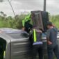 Petugas dari Satlantas Polres Solok saat melakukan penanganan dan evakuasi mobil Suzuki APV yang terguling keluar badan jalan di tikungan S, jalan Lingkar Solok-Padang. (Ist.)