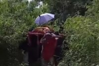 Warga menandu jenazah guru SDN 20 Lubuk Rasam melewati jalan rusak menuju Nagari Surian, Kecamatan Pantai Cermin, Kabupaten Solok, Senin (27/10/2025). (Ist.)