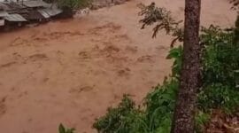 Kondisi air Sungai Lubuk Minturun yang telah naik signifikan dan berwarna cokelat pekat, Sabtu (6/12/2025). Pusdalops mengimbau warga yang tinggal di sekitarnya untuk segera menjauh.