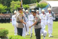 Mantan Kapolda Sumbar, Komjen Pol Gatot Tri Suryanto (kanan) menyerahkan Pataka Polda Sumbar kepada pejabat baru, Irjen Pol Djati Wiyoto Abadhy (kiri) dalam upacara Farewell Parade di halaman depan Mapolda Sumbar, Senin (6/7/2026). Prosesi penyerahan lambang kesatuan ini menjadi simbol resmi peralihan amanah dan tanggung jawab kepemimpinan korps Bhayangkara di Sumatera Barat. (Ist.)