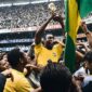 Penyerang Timnas Brasil, Pele, mengangkat trofi Piala Dunia pada edisi 1970. Pele mencatatkan diri sebagai satu-satunya pemain yang mengoleksi tiga gelar juara dunia, tepatnya pada edisi 1958, 1962, and 1970. Rekor tersebut hampir mustahil dapat disamai pada era sepakbola modern saat ini. (Ist.)