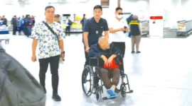 Tersangka kasus dugaan korupsi Pasar Atas Bukittinggi, YY (pakai kursi roda), dikawal ketat oleh Tim SIRI Kejagung usai diamankan di kawasan Serpong, Tangerang Selatan. (Ist.)