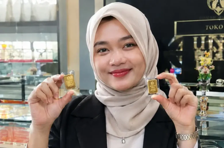 Karyawan sebuah toko emas memperlihatkan emas mini batangan.