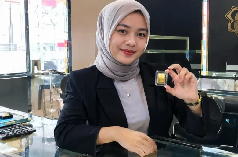 Pegawai Toko Emas Pegawai toko emas memperlihatkan emas batangan mini.