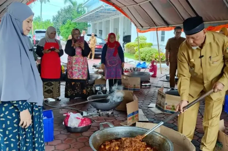Dokumentasi - Gubernur Sumbar Mahyeldi mengaduk rendang di kuali besar didampingi Istri Harneli Mahyeldi dalam aksi penggalangan bantuan pangan untuk korban bencana.