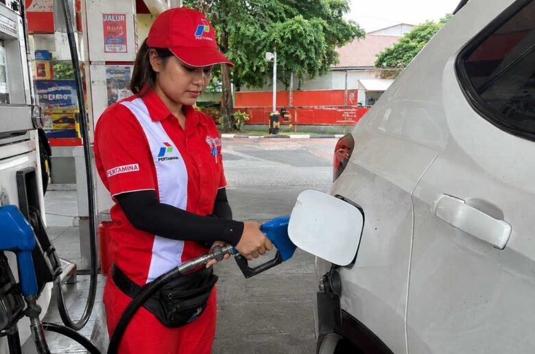 Daftar Harga BBM Terbaru Pegawai SPBU mengisi BBM ke mobil.