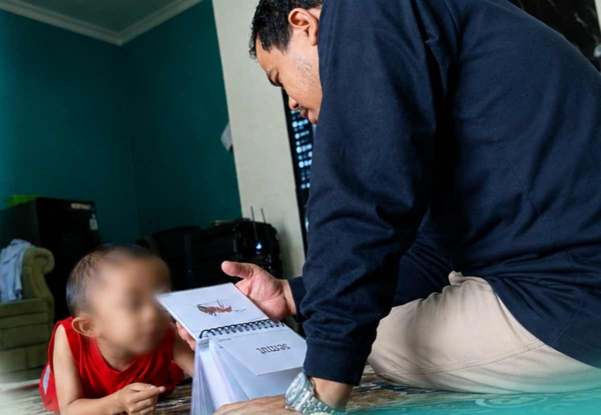 Tim dosen Terapi Wicara memperagakan penggunaan media gambar (flashcard) untuk melatih fokus dan kemampuan interaksi komunikasi anak.
