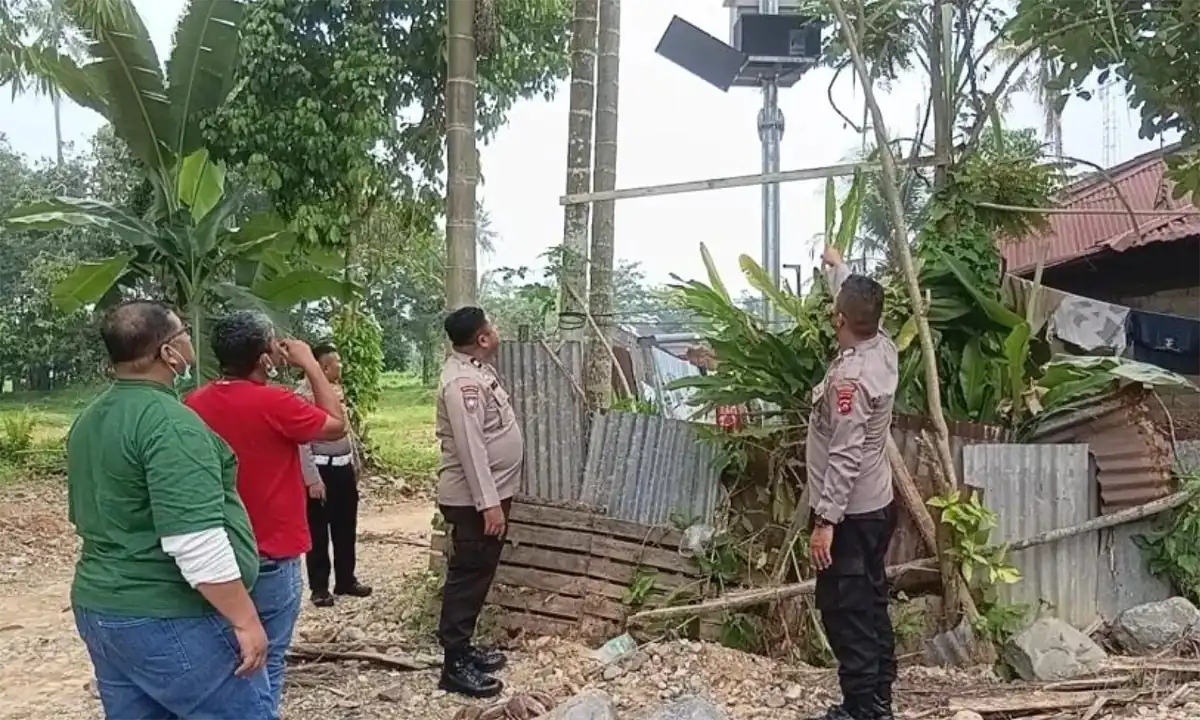 Petugas kepolisian dari Polsek Kuranji bersama jajaran BPBD Kota Padang dan tim teknisi memeriksa kondisi tiang boks panel EWS Banjir yang dibobol pencuri di kawasan Pasa Lalang, Kuranji, Padang, Sabtu (17/10/2026).
