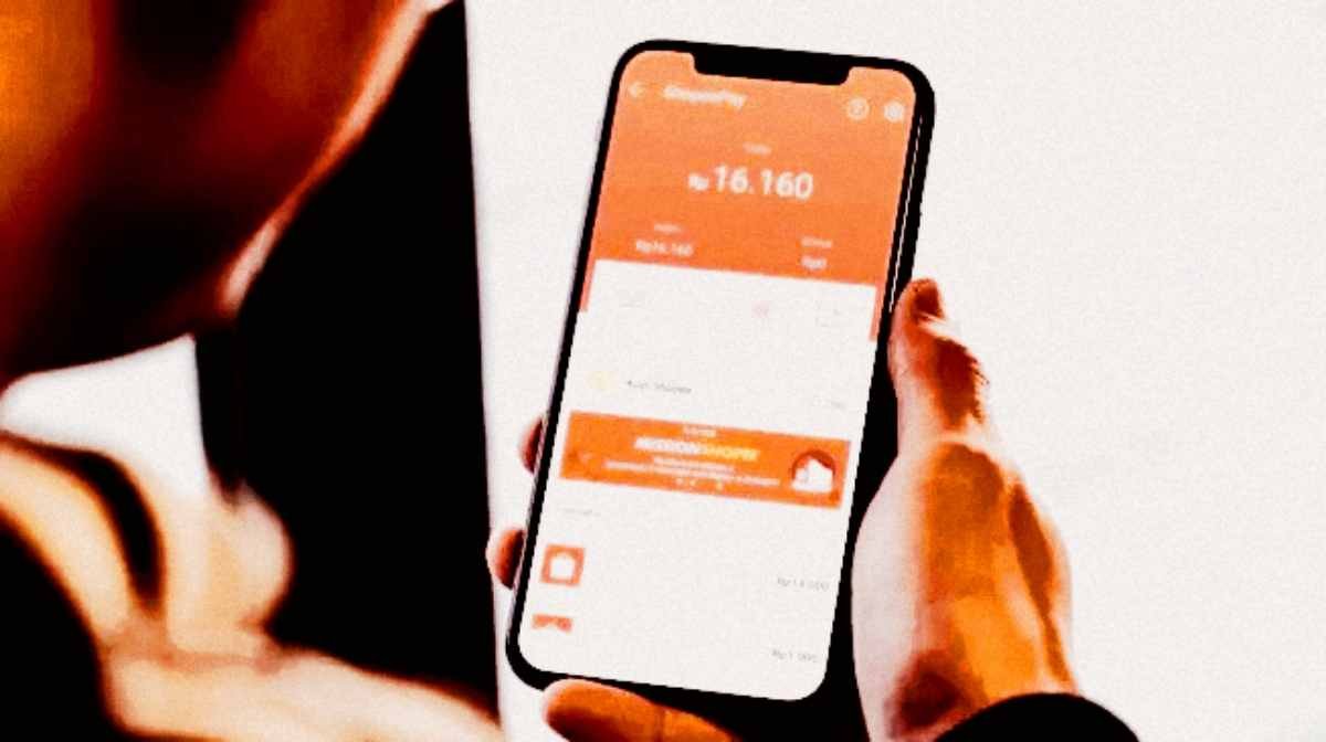 Seorang warga membuka aplikasi paylater di telepon genggamnya. Total utang pinjol dan paylater masyarakat menembus Rp150 triliun.